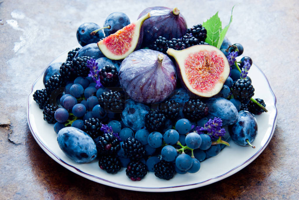 Fresh figs, grapes, prunes and dewberry on the plate