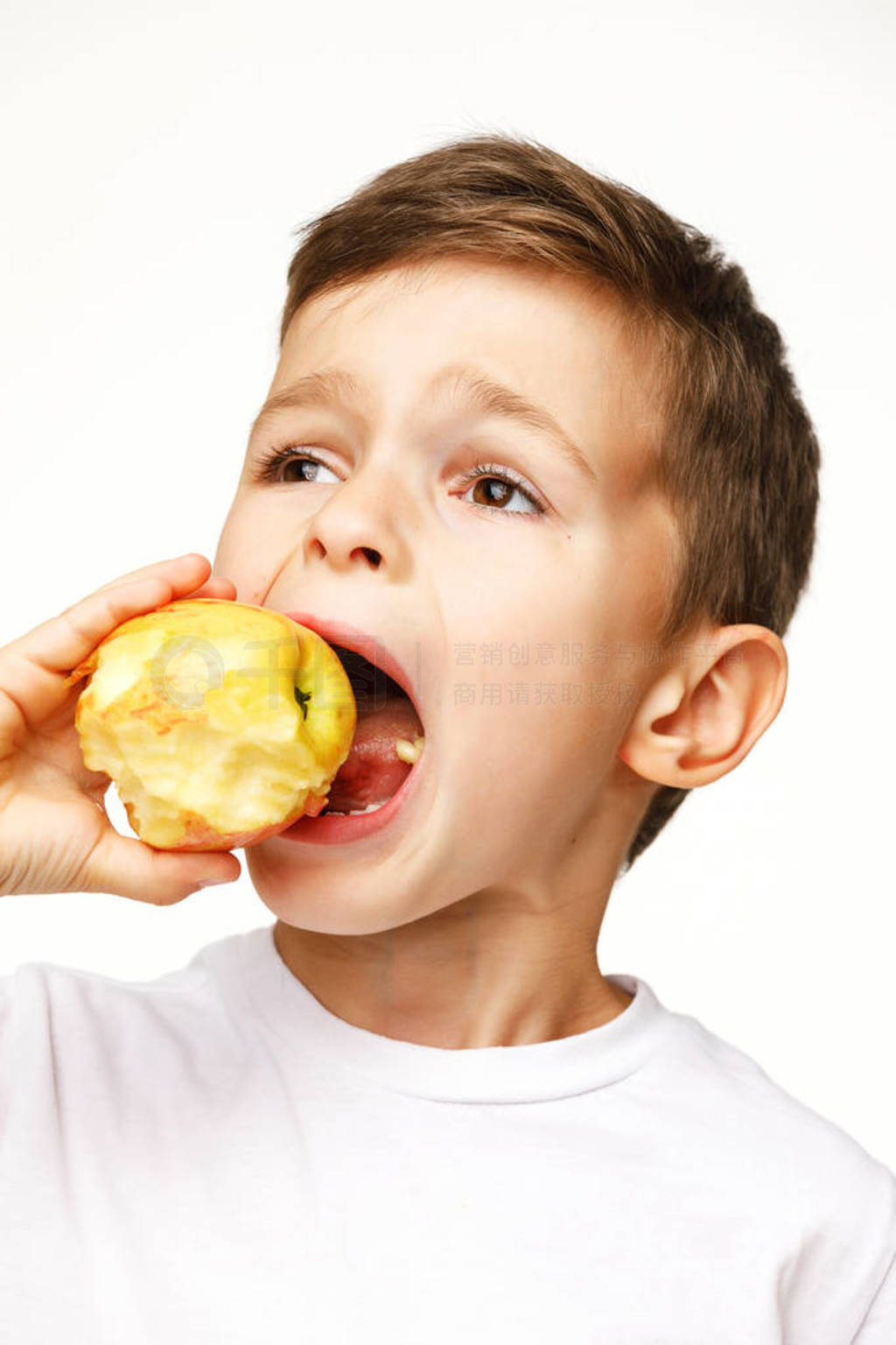 Little boy is eating apple studio shot