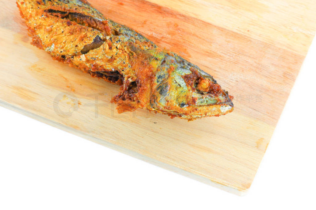 close up two fried mackerel on cutting board isolated white back