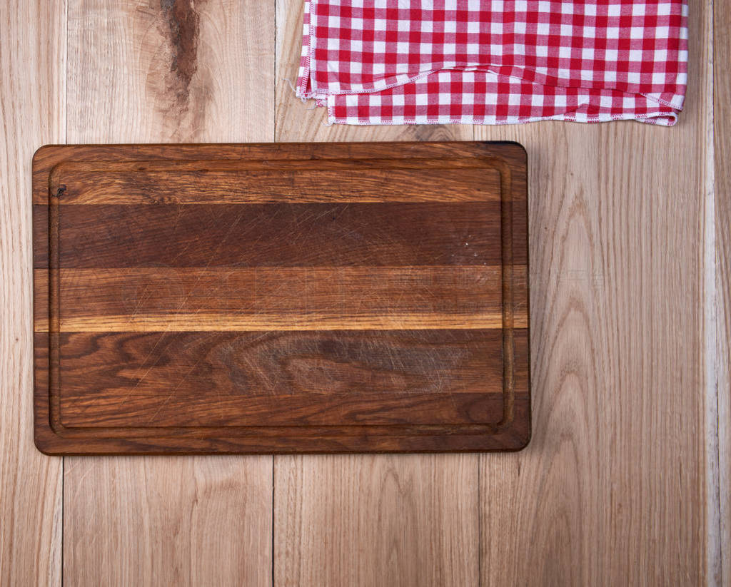 Empty old wooden kitchen cutting board and a red towel