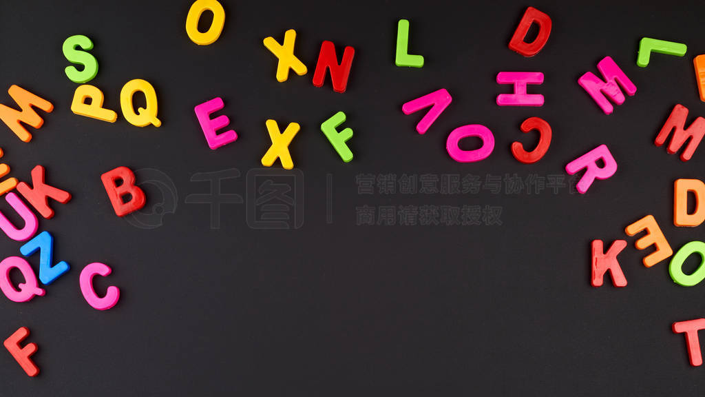 multicolored plastic letters of the English alphabet on a black