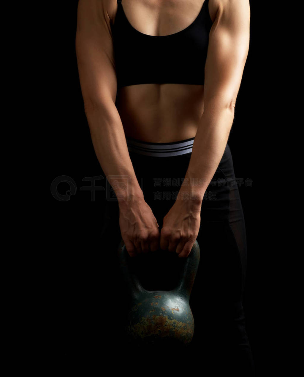 girl of athletic appearance holds an iron kettlebell