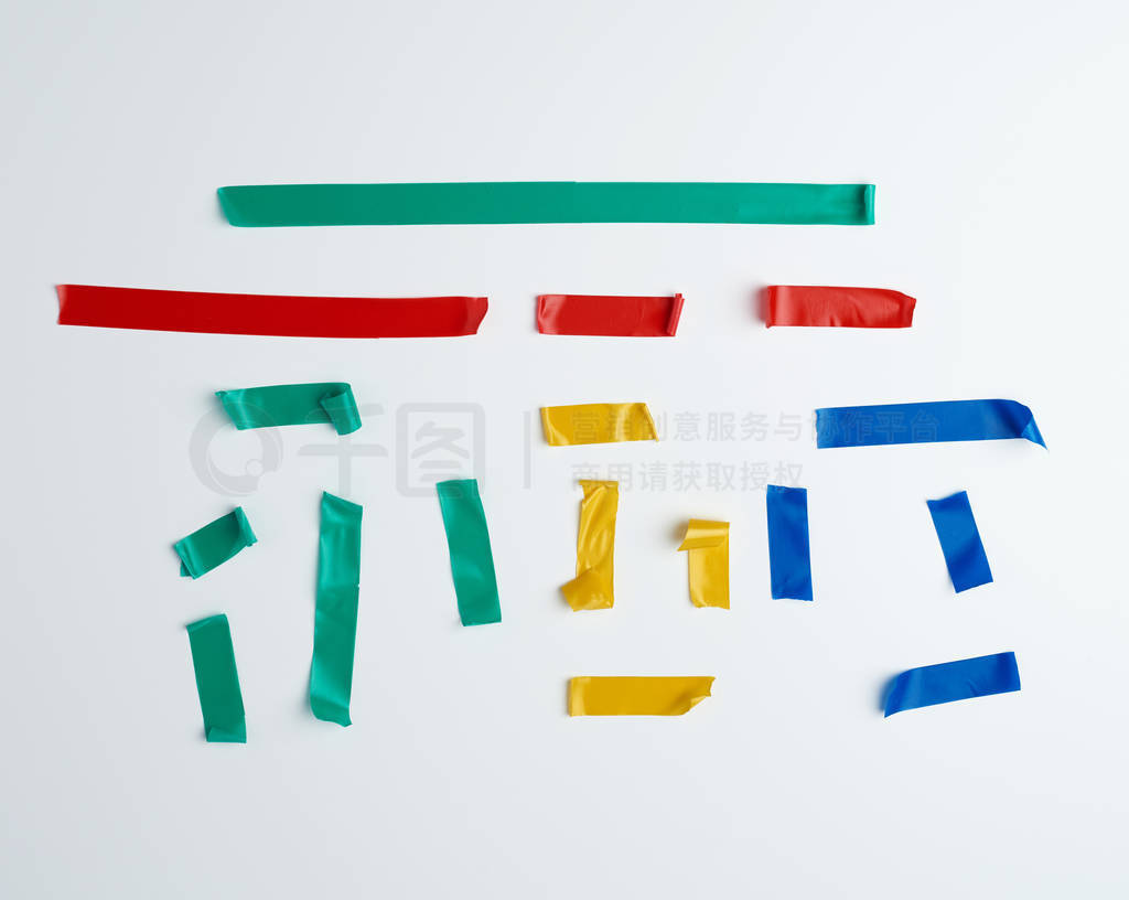 set of torn multicolored rubber pieces of electrical tape glued