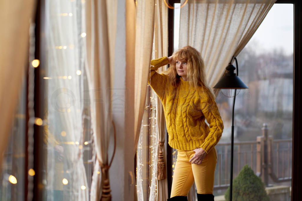 Portrait of a young pretty redhead woman wearing yellow sweater