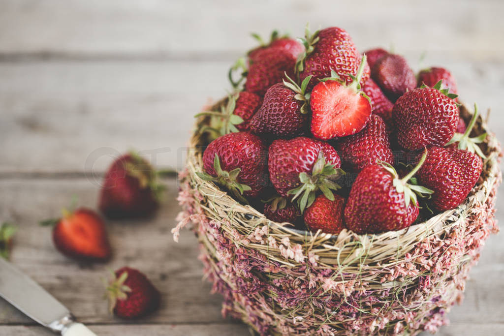 ripe strawberries in a beautiful basket on a wooden background