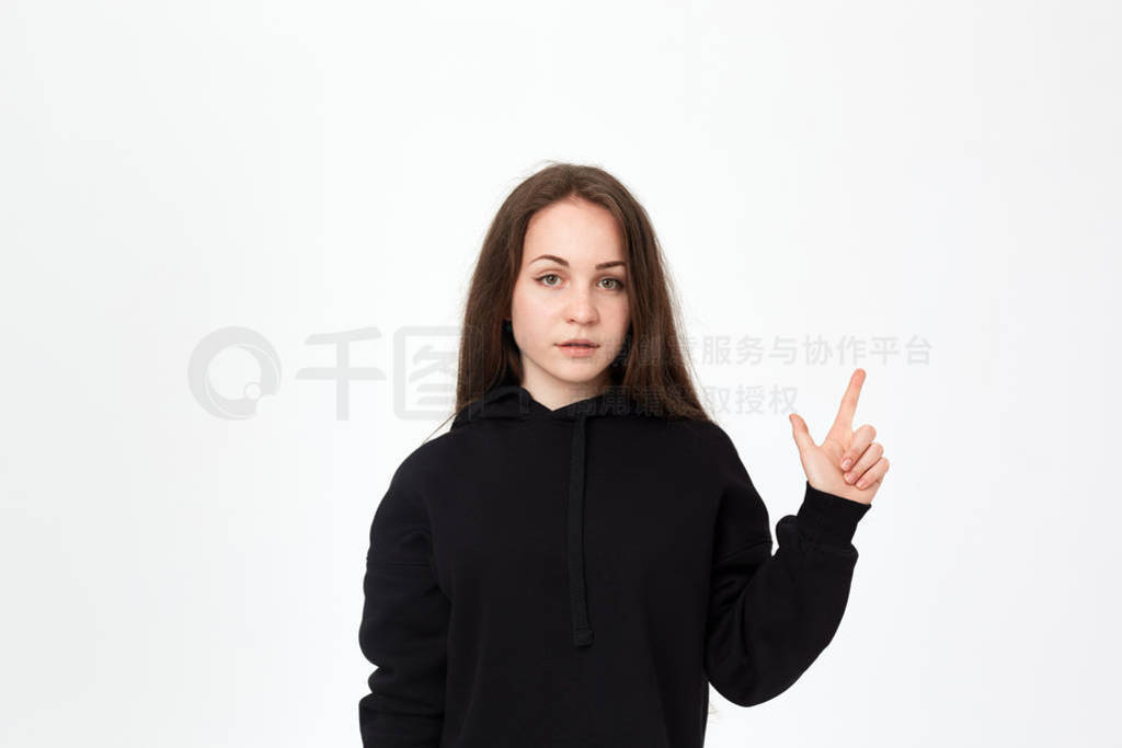 Portrait of a pretty young brunette in a black sweatshirt on a w