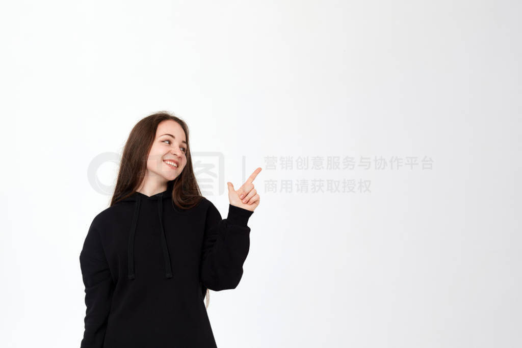 Portrait of a pretty young brunette in a black sweatshirt on a w