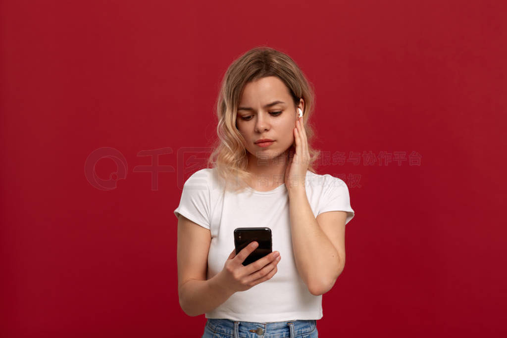 Portrait of a girl with curly blond hair in a white t-shirt on a