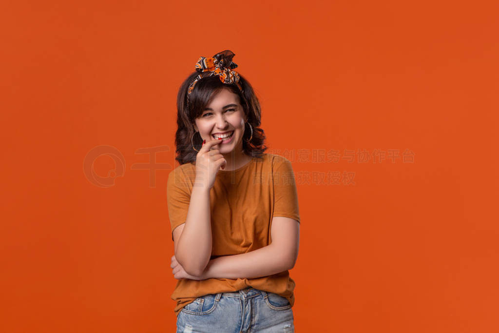 Smiling brunette woman in an orange t-shirt and beautiful headba