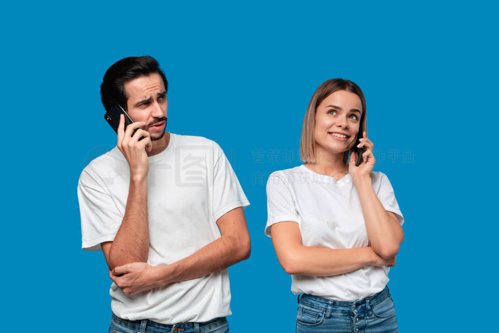 Blond woman and brunet man in white tees and blue jeans are surp