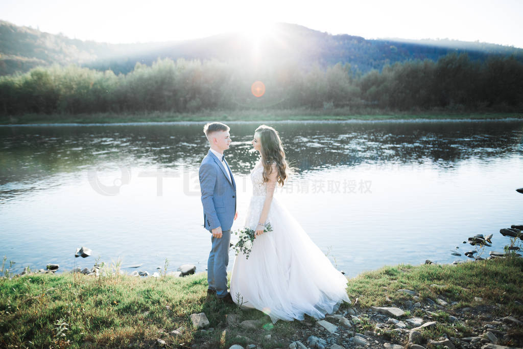 Elegant stylish happy blonde bride and gorgeous groom on the bac