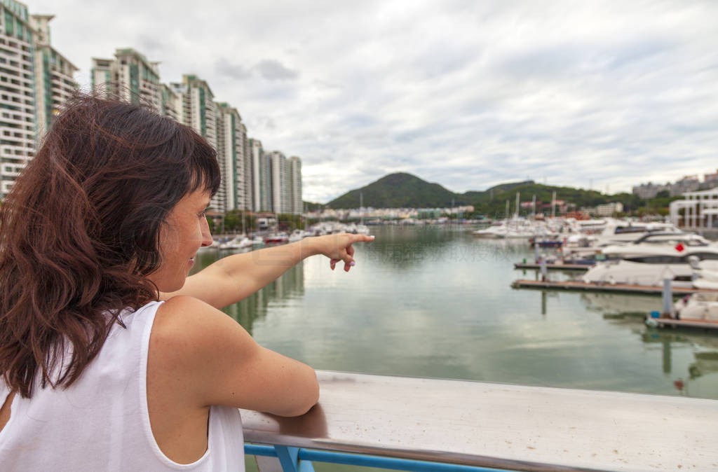 Holidays in Hainan, a girl shows her hand on a beautiful bay in