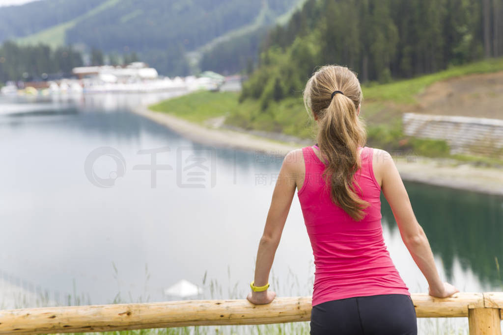 Back view of a young sportive woman in fitness clothes standing