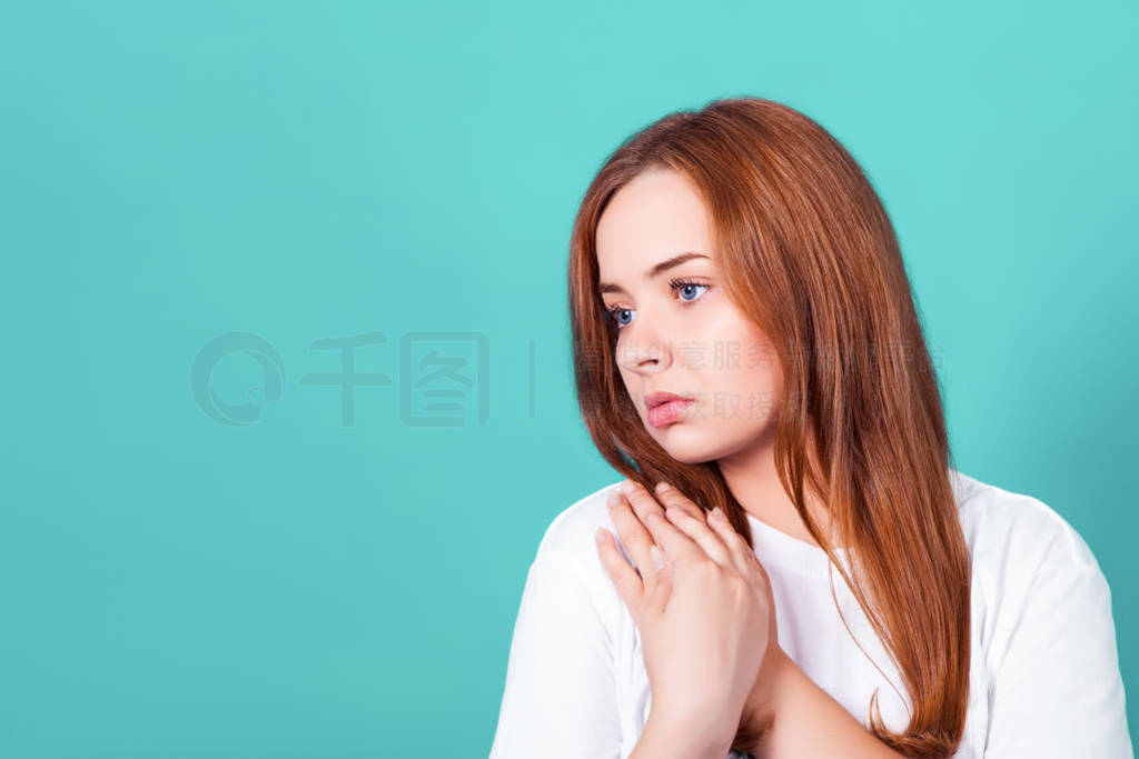 young attractive redhead girl sadly looks away. Studio shot