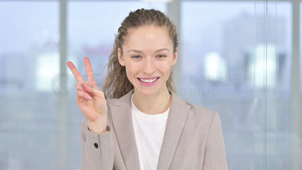 Portrait of Successful Young Businessman showing Victory Sign