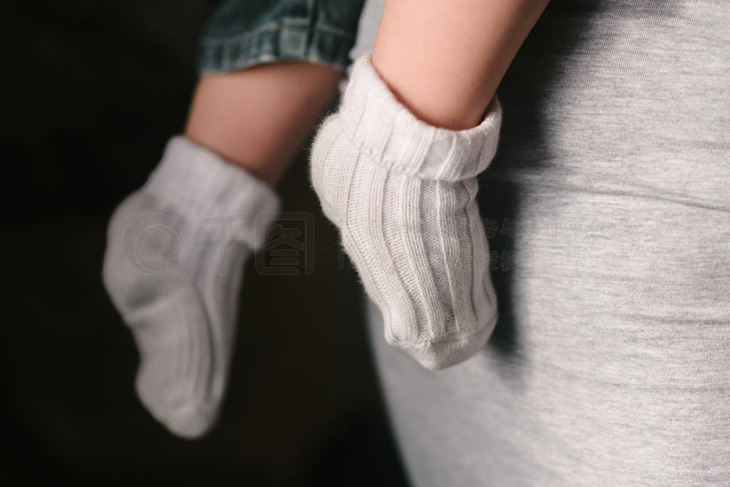 Legs of a small child in white socks. A happy family.