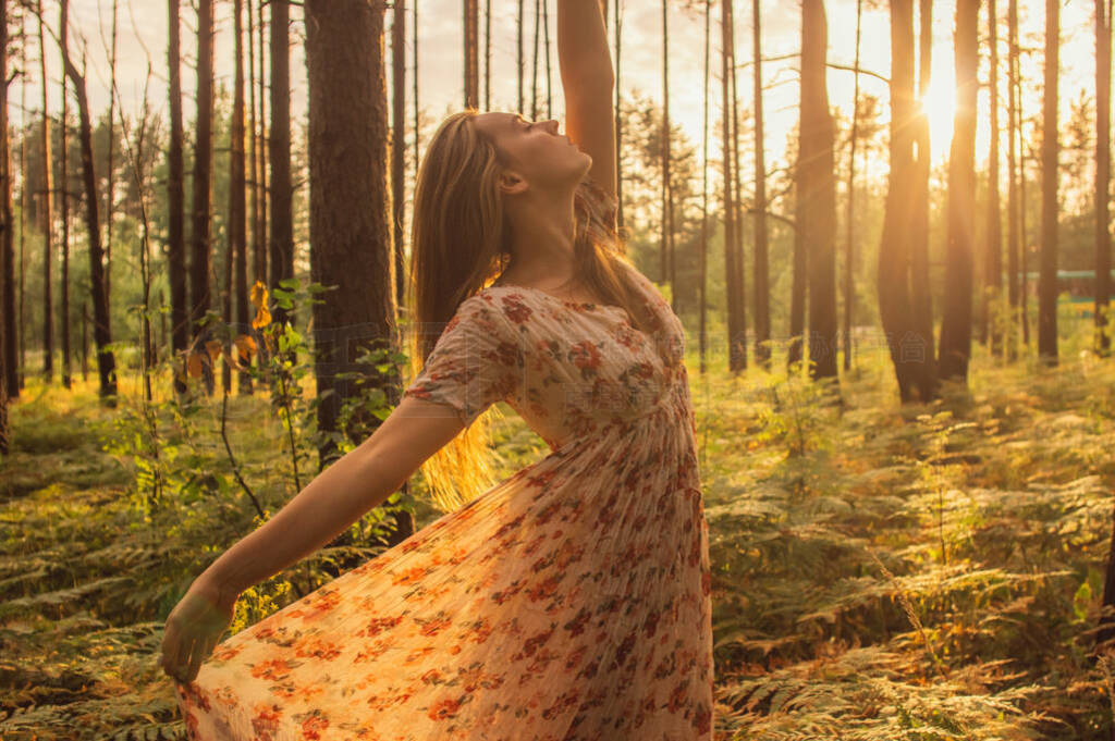 Portrait of young beautiful girl in summer dress in forest