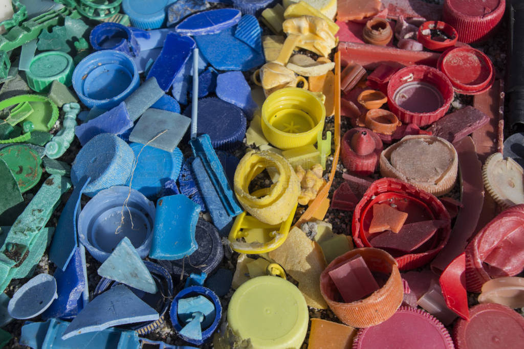 close-up of plastic trash spilled on the beach, dirty sea sandy