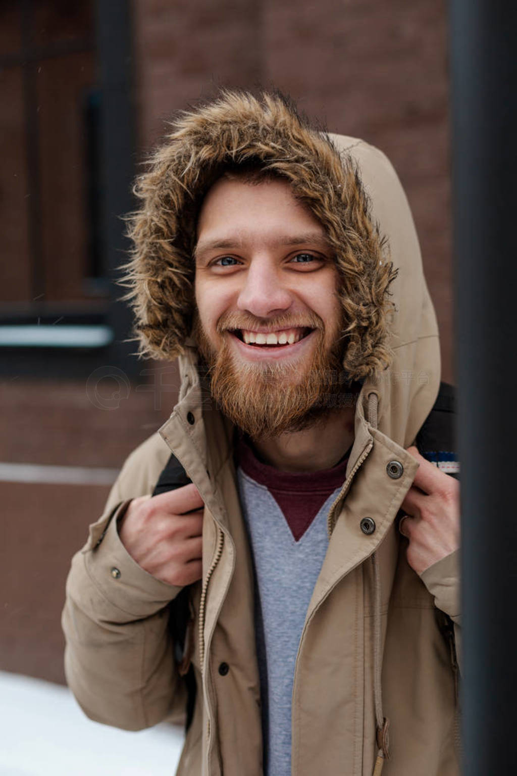 A young beard man walks in a winter coat