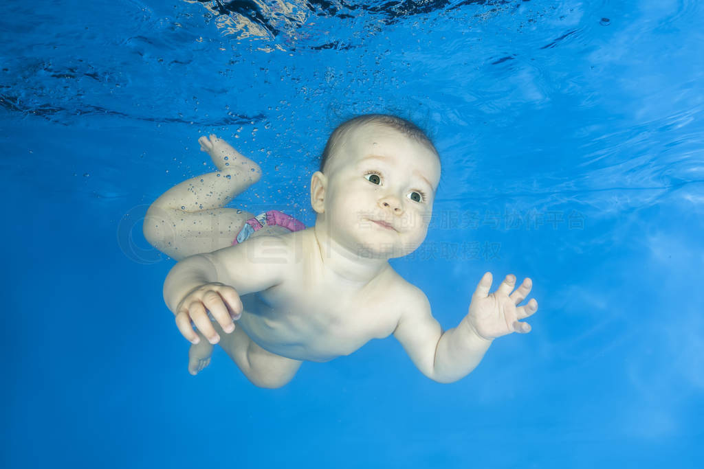 Little girl learns to swims underwater. Baby swimming underwater