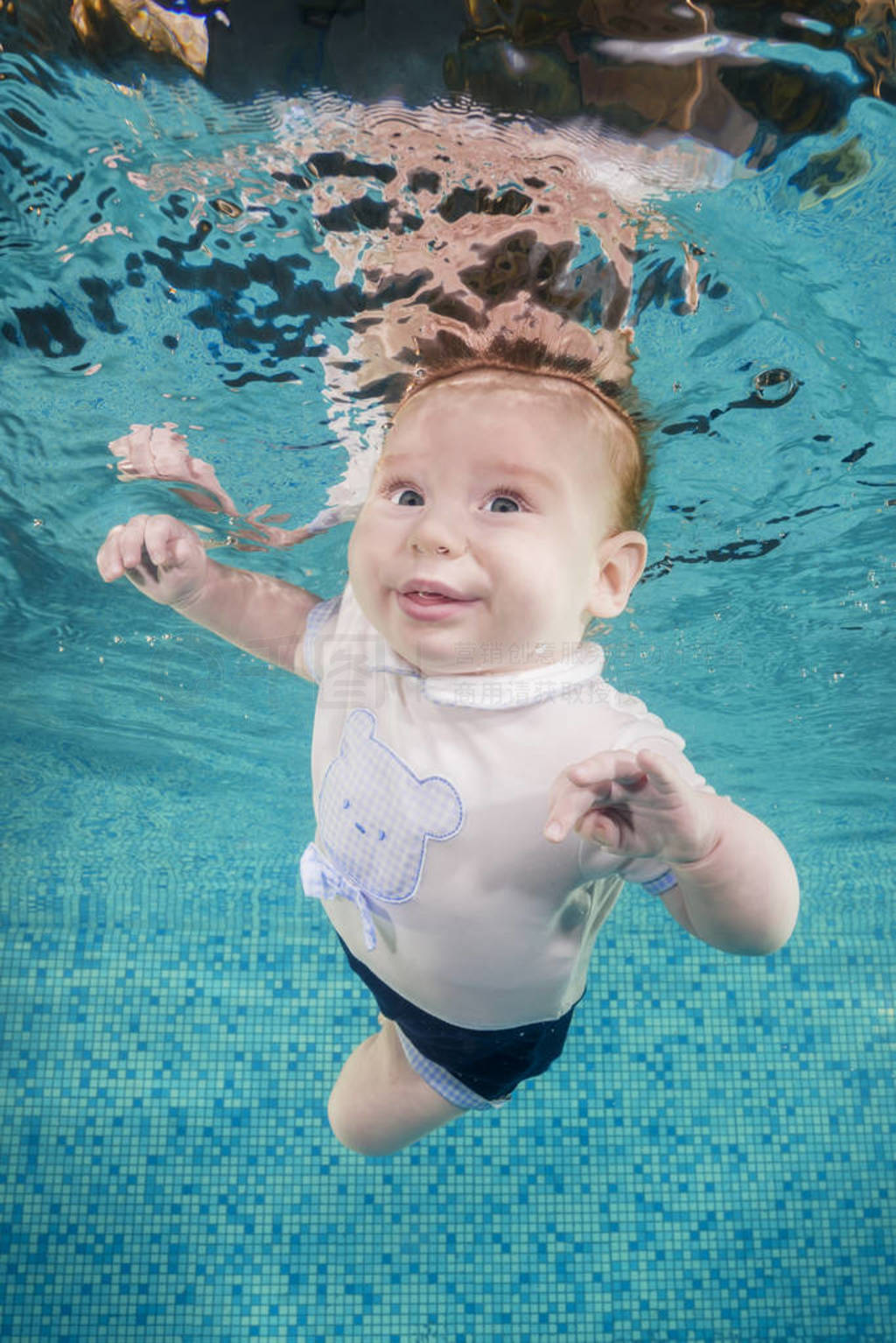 Funny face portrait of baby boy swimming and diving underwater w