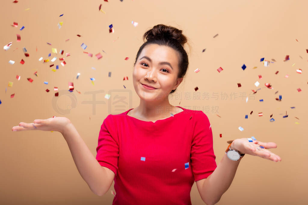 Portrait of a cheerful woman with confetti rain and celebrating