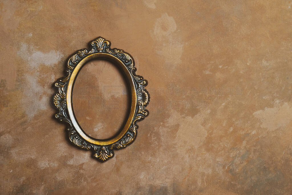 Empty oval bronze picture frame on vintage brown wall. Photo fra