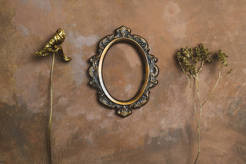 Empty vintage oval photo frame and twigs of dried flowers on dec