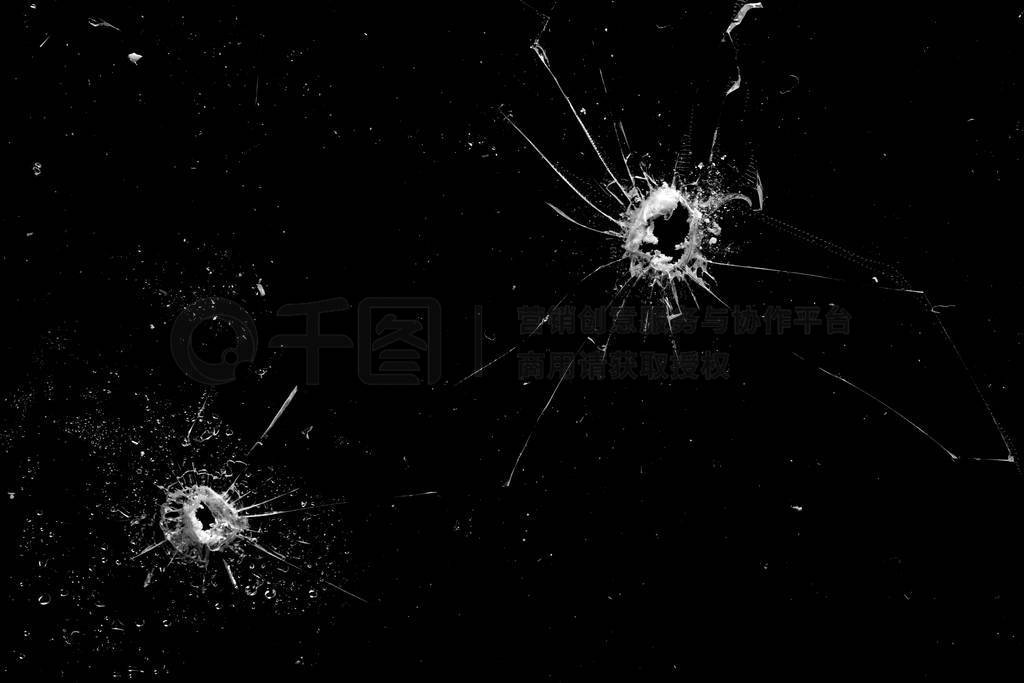 holes in the glass with cracks isolated on a black