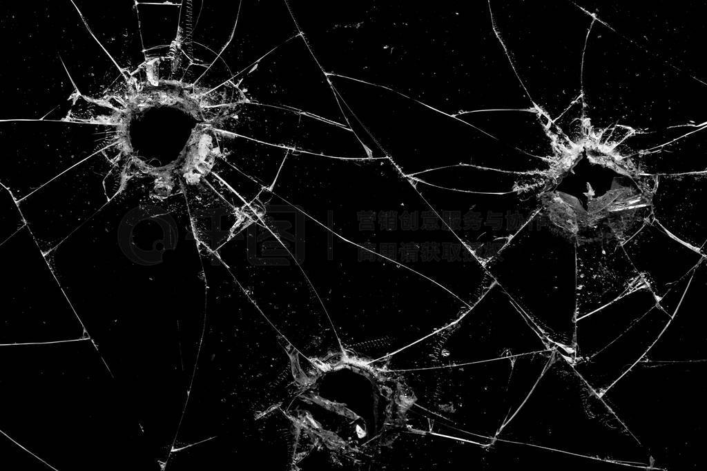 holes in the glass with cracks isolated on a black
