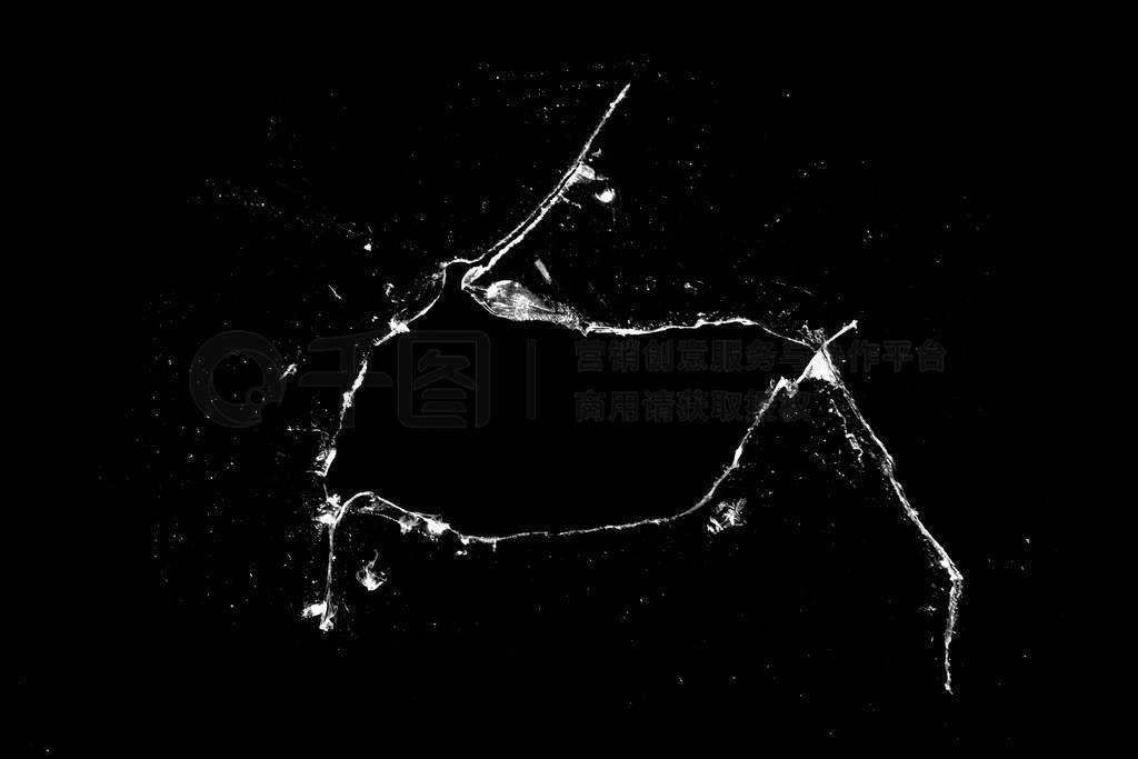 hole in the glass with cracks isolated on a black background.