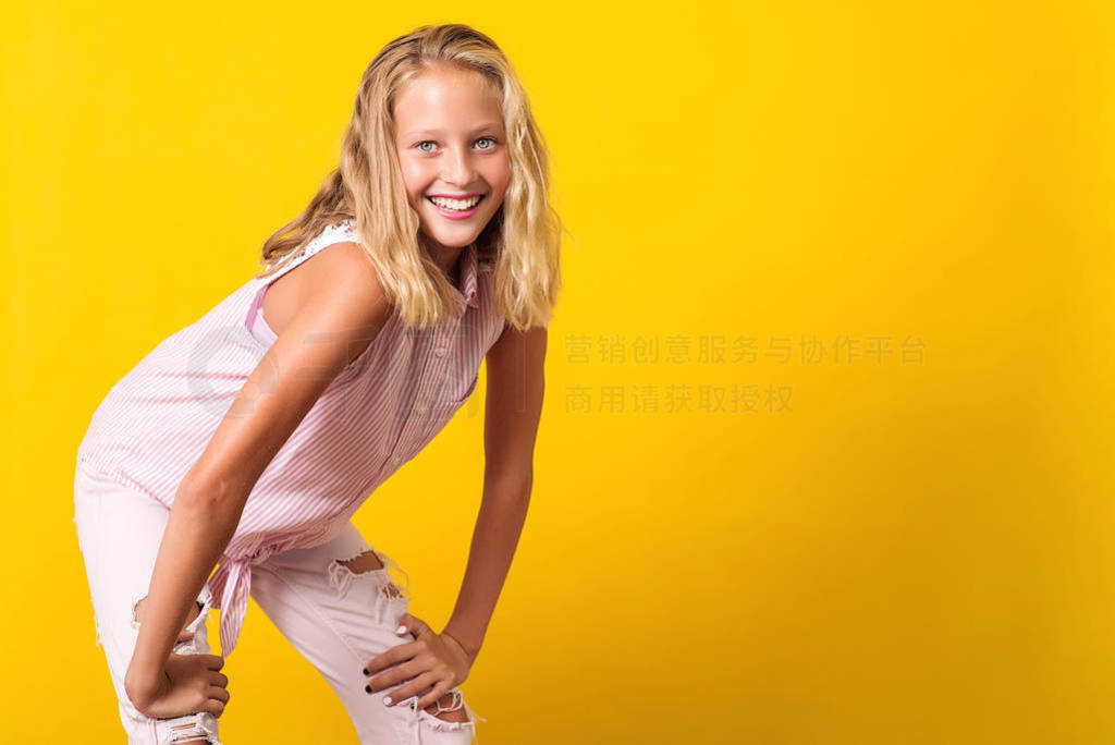 Cute pre-teen girl wearing fashion summer clothes posing on yell