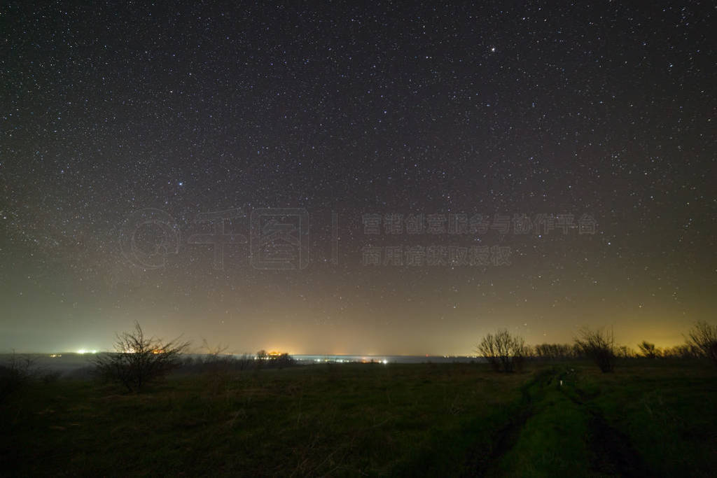 Stars in the night sky over a dirt road. Landscape photographed