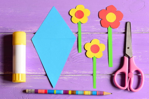 为母亲的一天或生日制作纸制工艺品。一步。纸质花，剪刀，胶水粘花模板，用铅笔在桌子上。在家中或在幼儿园为孩子艺术活动设置。顶视图
