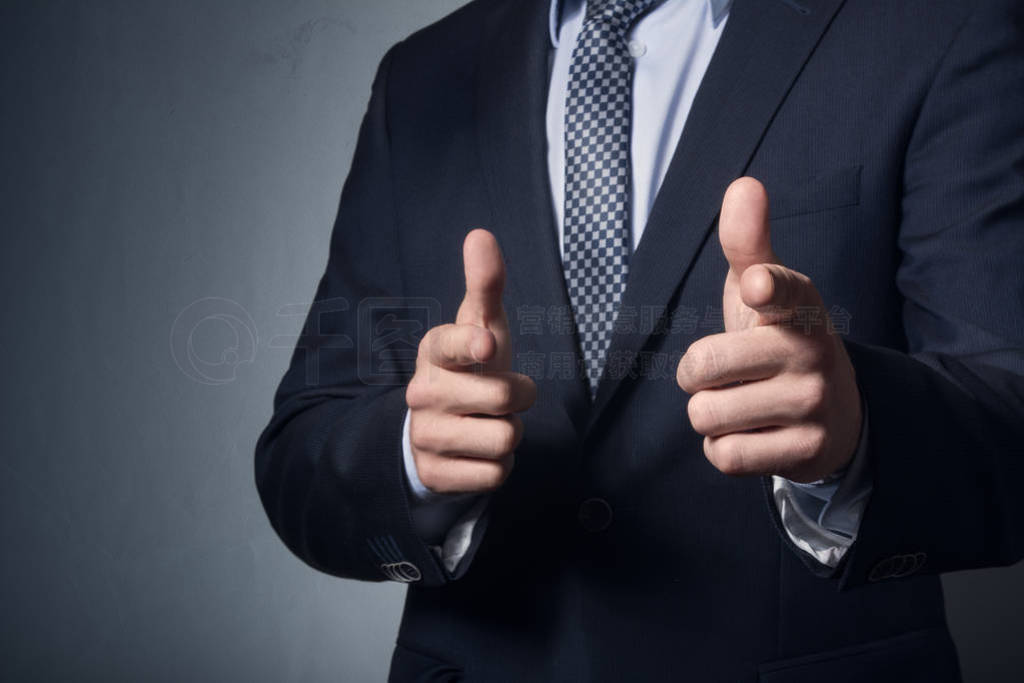 a man business suit points finger.