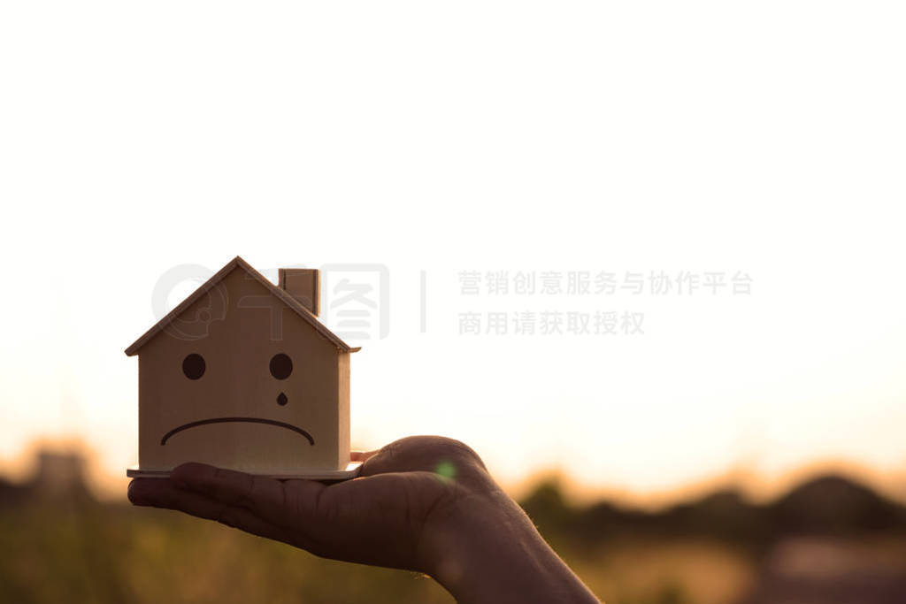 Closeup hand holding mockup house wood with face sad emotion at