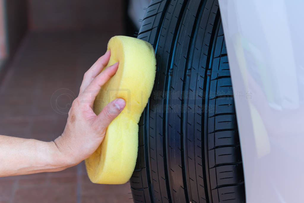 Cleaning car wheel, wiping tire after cleaning on car washing.