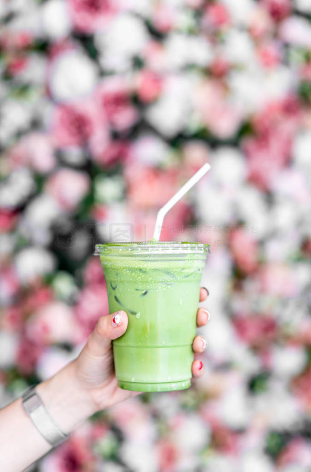 hand holding iced matcha latte green tea cup