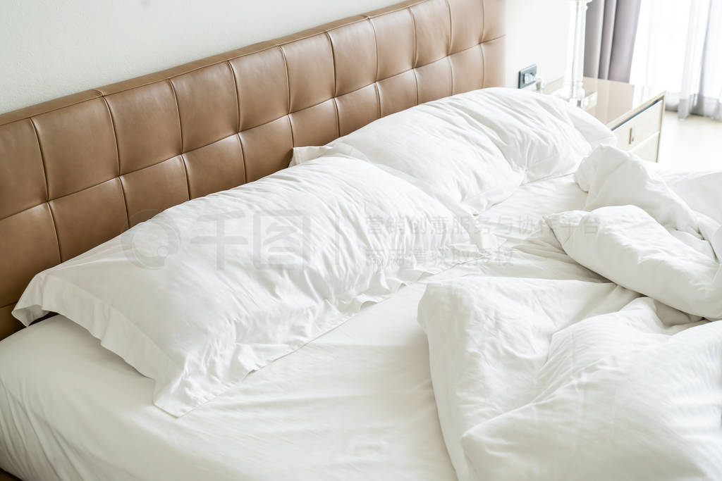 Messy bed with white pillow and blanket on bed