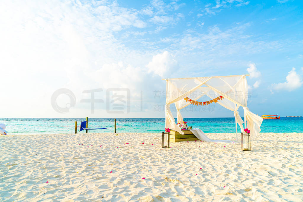 wedding arch on beach with tropical Maldives resort and sea