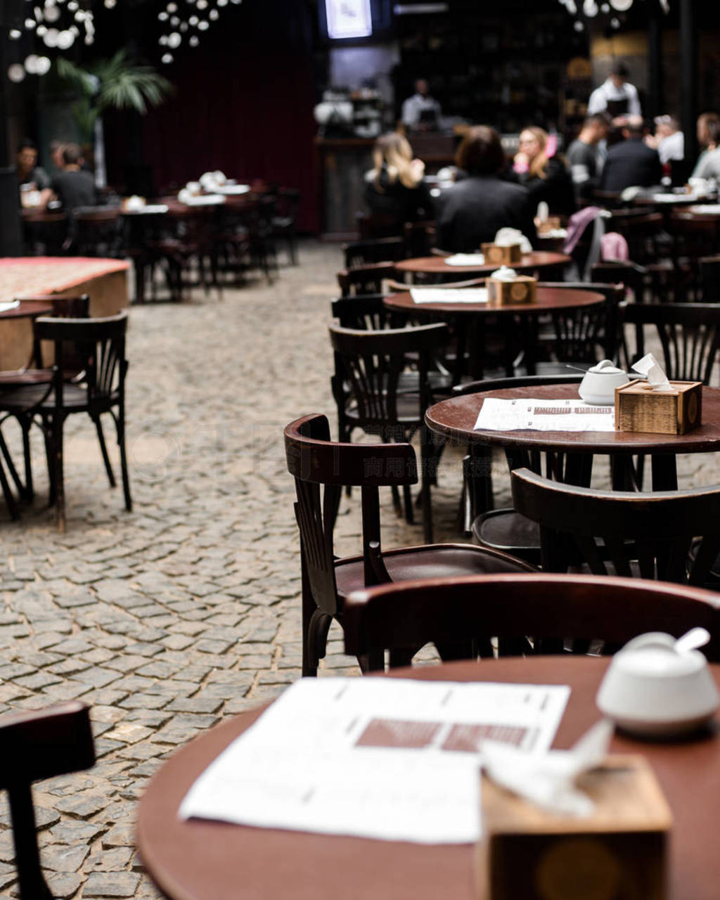 Empty chairs and tables with menu in outdoor cafe and Blur resta