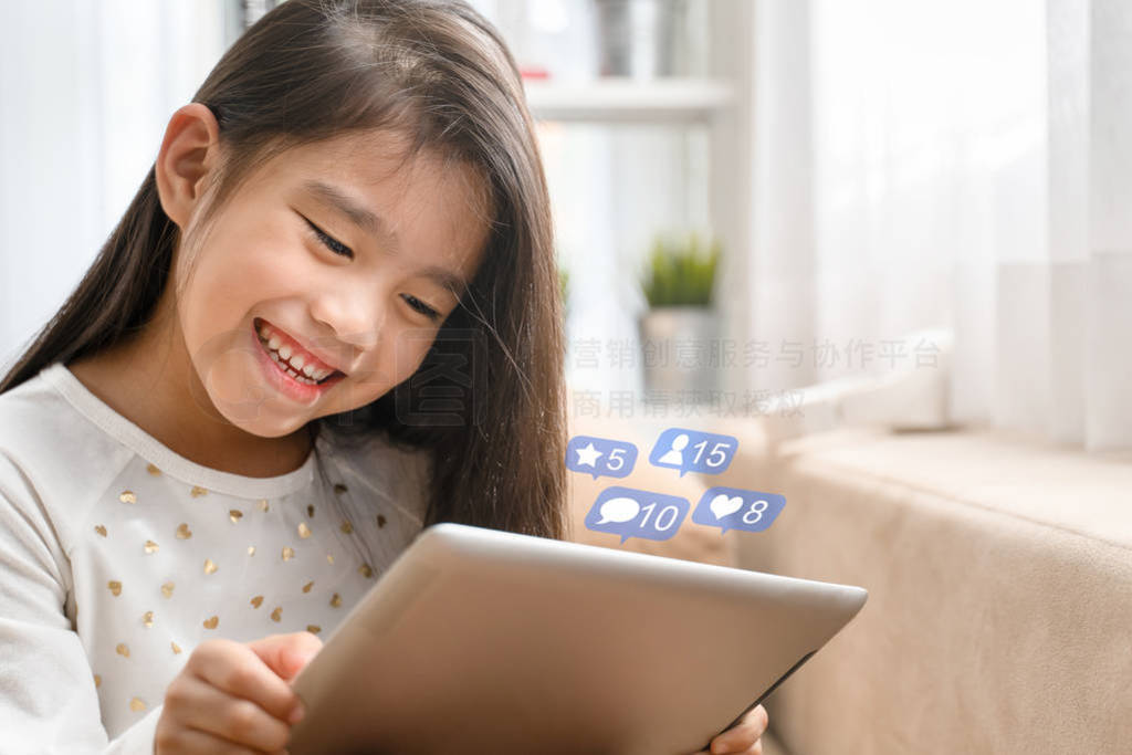 Asian Cute child playing games with a tablet and smiling while