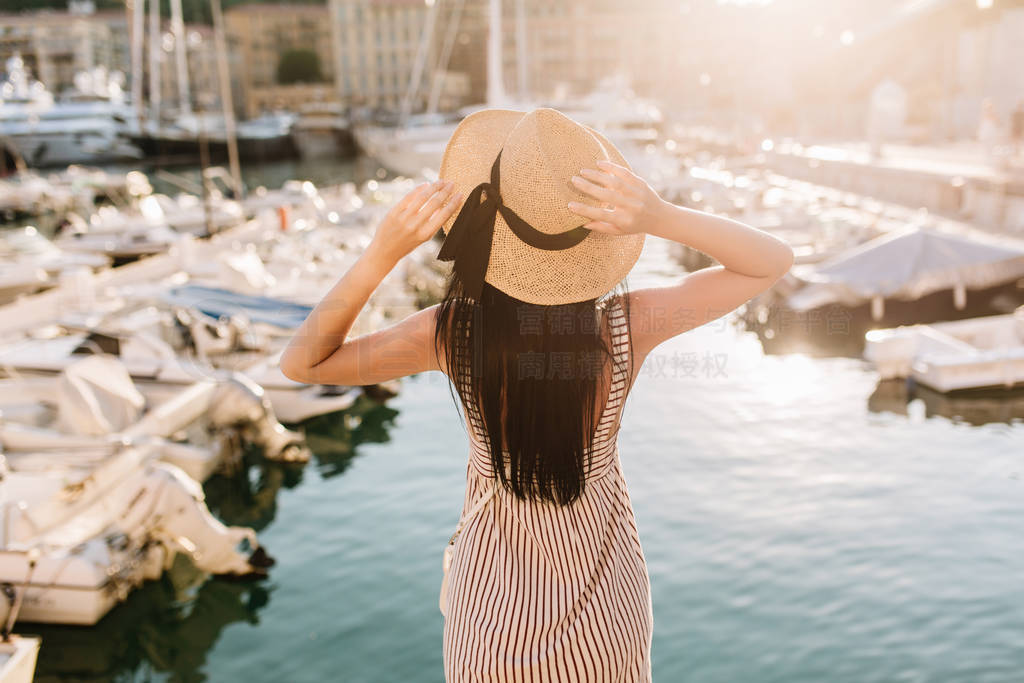 Elegant slim girl with trendy hairstyle spending time in seaport