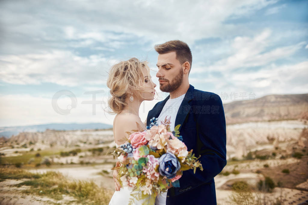 Couple in love hugs and kisses in fabulous mountains in nature.