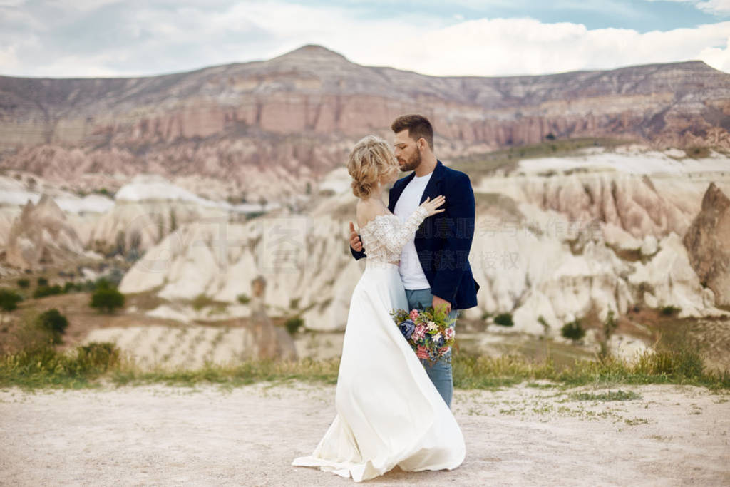 Couple in love hugs and kisses in fabulous mountains in nature.