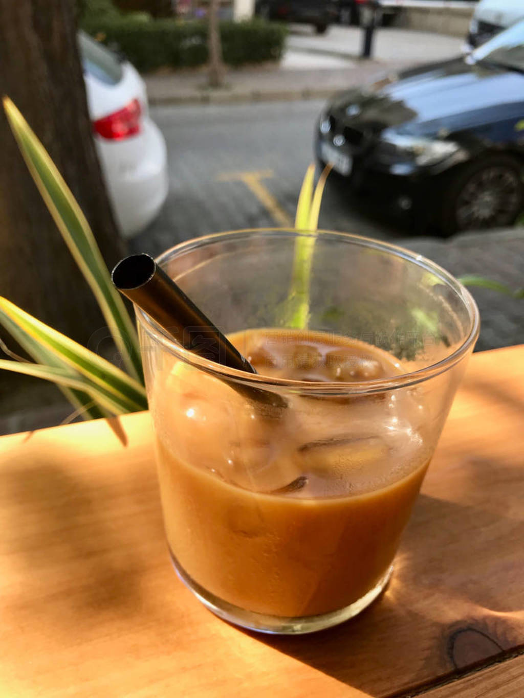Iced Americano with Milk and Ice Cubes on Wooden Table with Blac