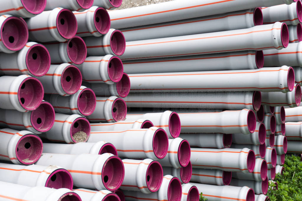 many stacked long plastic pipe tubes ready for building a water