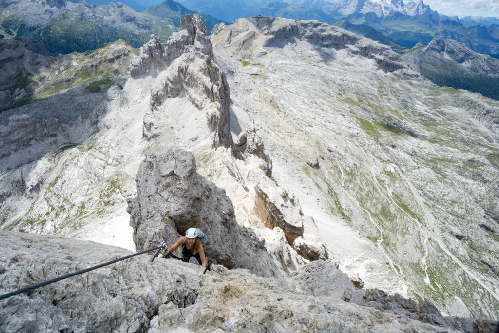 attractive female climber on a steep Via Ferrata in the Italian