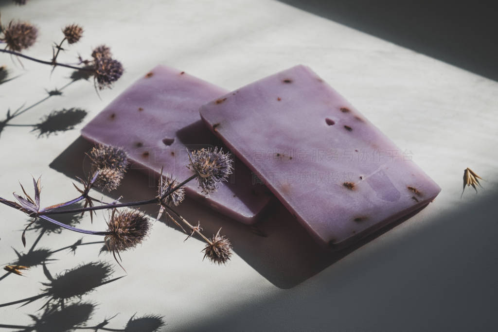 Natural lavender soap bars with dried flowers in natural light.