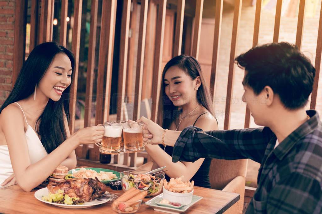 Group of asian people cheering beer at restaurant happy hour in